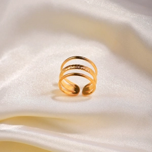 Detail of 18k gold layered ring with hammered texture resting on white silk fabric
