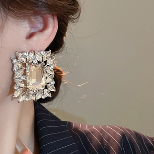 Close-up of large square crystal earrings with silver-tone metal and sparkling details