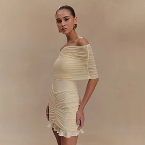 Détail de robe beige à épaules dénudées avec tissu froncé et ourlet à volants