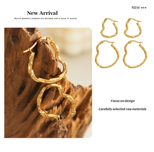 Detail of gold heart earrings with twisted wave texture in small and large sizes