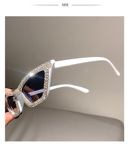 Detail view of white cat-eye sunglasses featuring side frame encrusted with sparkling crystals