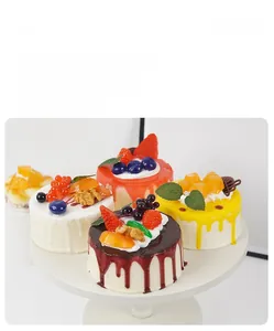 Detailed assortment of artificial fruit mousse cakes with realistic jam and strawberry toppings