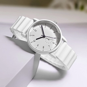 Macro view of white quartz watch featuring a unique wavy silicone strap and numeric dial