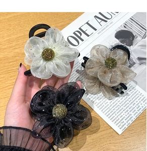 Details of mesh flower hair claws with glitter and gold beads in three soft colors