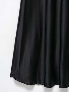 Detailed macro view showing the drape and smooth texture of high-quality black satin fabric