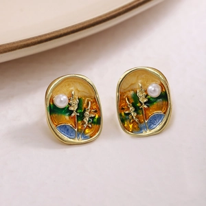 Macro view of vintage French oil painting style wheat earrings with enamel and pearl details