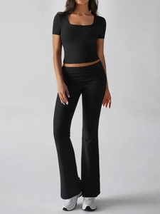 Detail of a slim-fit black Y2K two-piece set featuring a cropped tee and flare pants