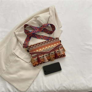 Close-up of bohemian shoulder bag with ethnic patterns and colorful fringe detail