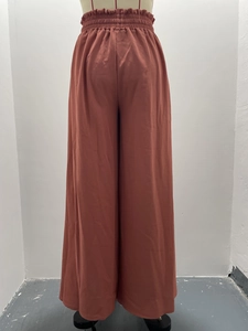 Détail de la taille haute élastique sur le pantalon large rouge rouille pour femme