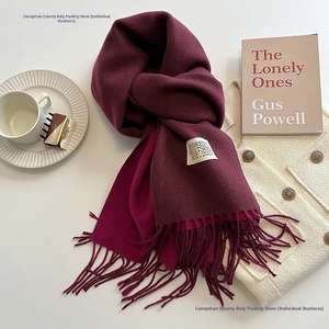 Detail of burgundy faux cashmere scarf with fine twill texture and fringed edges