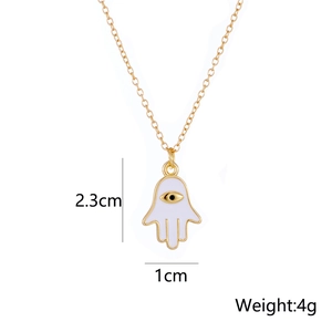 Detail view of gold-plated Hamsa necklace with white enamel eye and 2.3cm x 1cm dimensions