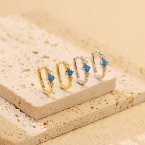 Vista macro degli orecchini a U in argento S925 con opale blu e zirconi brillanti