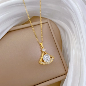Vue macro du pendentif en forme d'éventail doré avec zircon brillant et pavé de cristaux