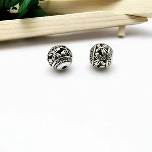 Macro shot of hollow silver flower beads with vintage patterns for jewelry making