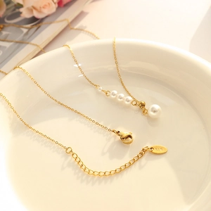 French vintage style gold chain pearl necklace with K18 hallmark on white ceramic tray