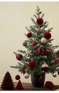Close-up of red flocked balls, gold glitter ornaments and paper honeycomb Christmas tree