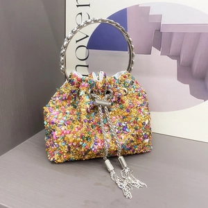 Detail view of colorful crystals and gold metal handle on a luxury evening bucket bag