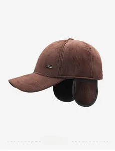 Detail of dark brown corduroy winter baseball cap with integrated ear flaps and metal logo