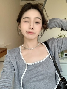 Model wearing large silver hoop earrings and a minimalist pearl metal chain necklace