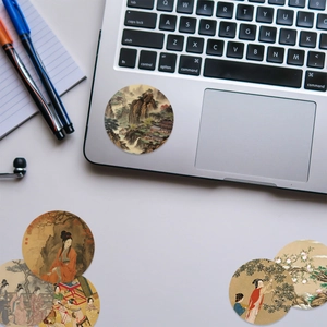 Nahaufnahme von chinesischen Kunstaufklebern mit Landschaften und Figuren auf einem Laptop