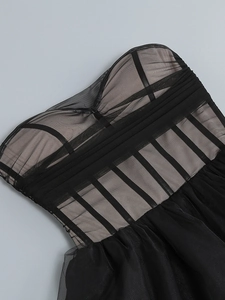 Detailed macro view of corset-style black mesh dress with intricate bone structure and beads