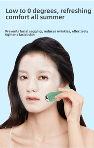 Close-up of a light green facial ice roller with metal head used over a sheet mask