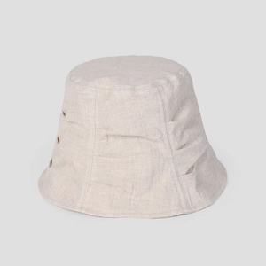 Detail of pleated texture on a breathable linen bucket hat in beige for women