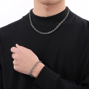 Minimalist stainless steel chain necklace and bracelet set shown on a male model