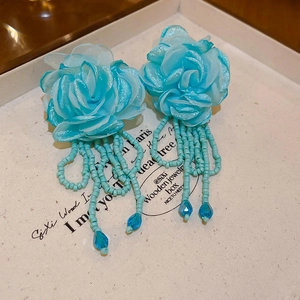 Detailed close-up of blue mesh flower drop earrings with beads and water drop crystals