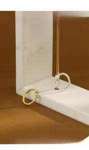 Close-up of gold and silver textured lava rings with pearl and zircon stone accents