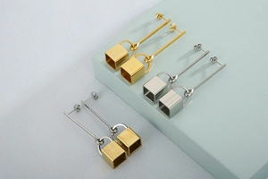 Detailed view of minimalist geometric drop earrings in gold and silver square metal finishes