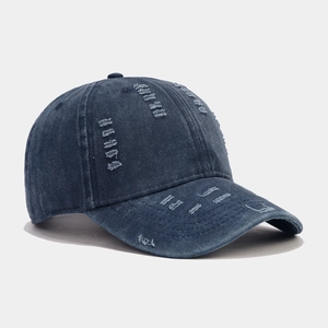 Close-up of distressed denim baseball cap with vintage washed details and ripped textures