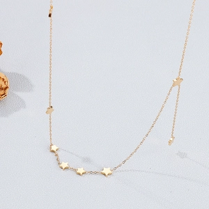 Macro shot of multiple polished gold star charms on a titanium steel necklace chain