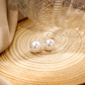 Macro view of twin white pearls with high luster on a natural wood ring tray detail