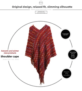 Détail du châle cape en tricot rouge avec motifs ondulés et longues franges
