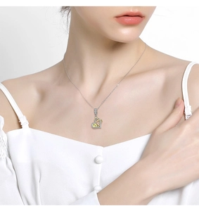 Close-up of infinity heart pendant in 925 silver with gold accents on model neck