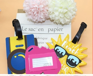 Detailed view of yellow pineapple and camera PVC luggage tags with contact info cards