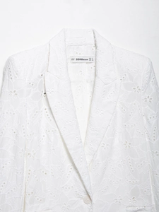 Gros plan sur l'étiquette BBWM WOMAN et la broderie florale délicate du blazer blanc