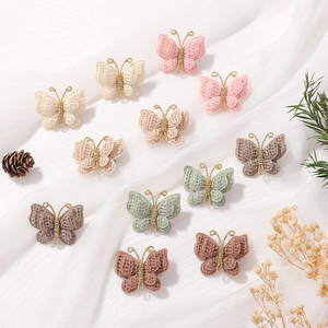 Détail de pinces papillon en crochet faites main aux couleurs Morandi et fil doré