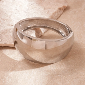 Macro shot of silver metallic wide cuff bracelet with a polished mirror finish detail