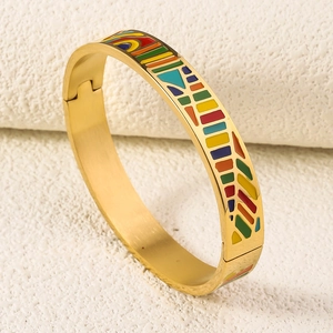 Detail of 18K gold-plated stainless steel bangle with colorful enamel geometric patterns