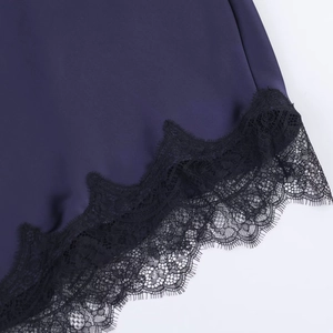 Detailaufnahme von dunklem lila Satinstoff mit feiner schwarzer Wimpernspitze vernäht
