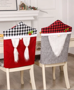 Gemütliche Weihnachts-Stuhlhussen mit roten und grauen Zwergenmotiven auf einem Holztisch