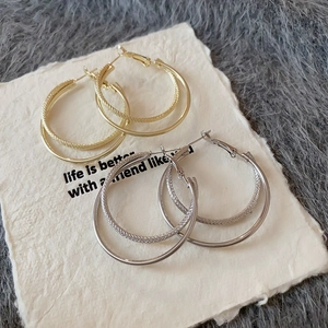 Detail showing gold and silver double-hoop earrings with smooth and twisted textures