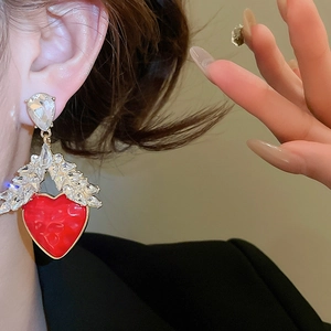 Gros plan de boucles d'oreilles cœur en résine rouge avec détails en épis de blé