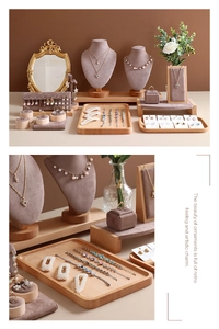 Detail showing elegant gold jewelry collection on beige velvet display with wooden base