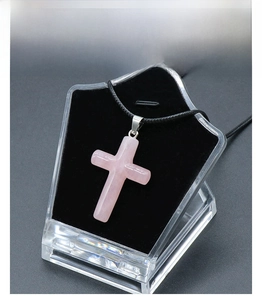 Detailed view of large natural rose quartz cross pendant with a smooth polished finish