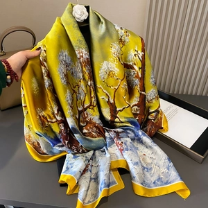 Elegant yellow silk scarf with winter landscape print on a mannequin for sun protection