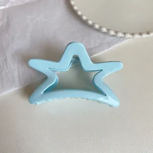 Detailed view of a light blue star-shaped acrylic hair claw clip with glossy hollow design