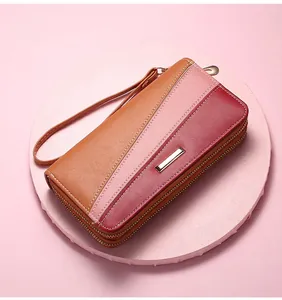Detail view of tri-color patchwork leather wallet with double zippers and wrist strap